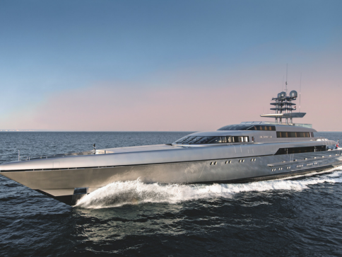 A sleek, modern luxury yacht cruises through calm blue waters under a clear sky, creating a white wake at its bow.