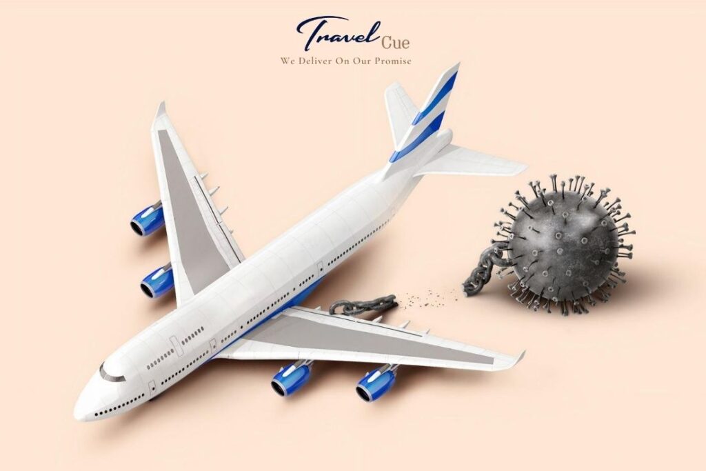 A large passenger aeroplane is chained to a spiky, metallic ball resembling a coronavirus particle. The chain restricts the plane’s movement, symbolising travel limitations due to COVID-19. Travel Cue logo is at the top.