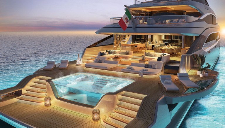 Luxurious yacht at sunset, featuring an illuminated deck with a large hot tub, elegant lounge seating, and an open indoor dining area. The yacht is on calm blue water with an Italian flag at the aft.
