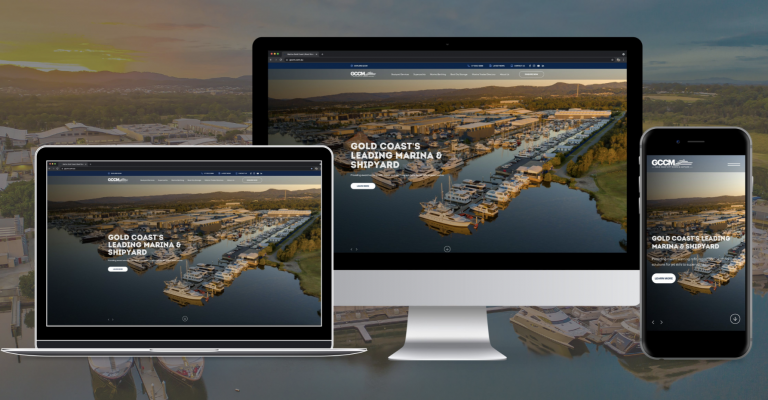 A laptop, desktop, and mobile phone display the same marina website with aerial view of boats and docks, demonstrating the site’s responsive design across multiple devices.