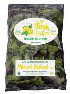A clear plastic bag labelled Fresh Farm Seriously Fresh Stuff contains 250g of mixed salad leafy greens. The packaging features green and yellow text with images of leafy greens and a lemon.
