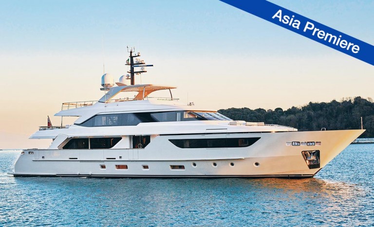 A large white luxury yacht floats on calm water near a forested coastline at sunset. A blue banner in the top right corner reads Asia Première.