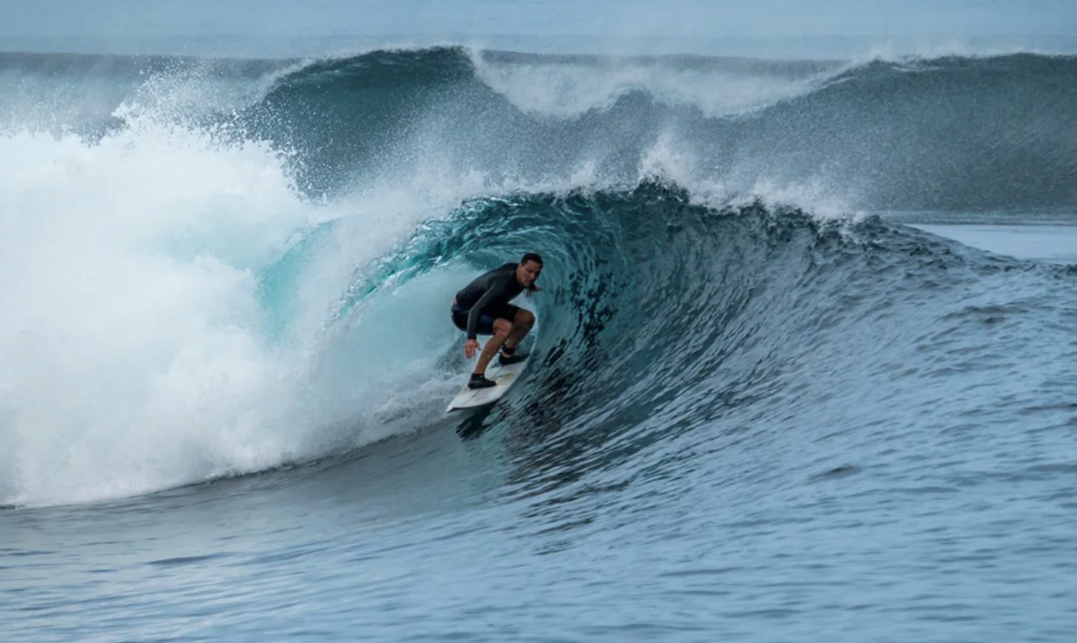 Surfer riding a barrelling wave in Indonesia